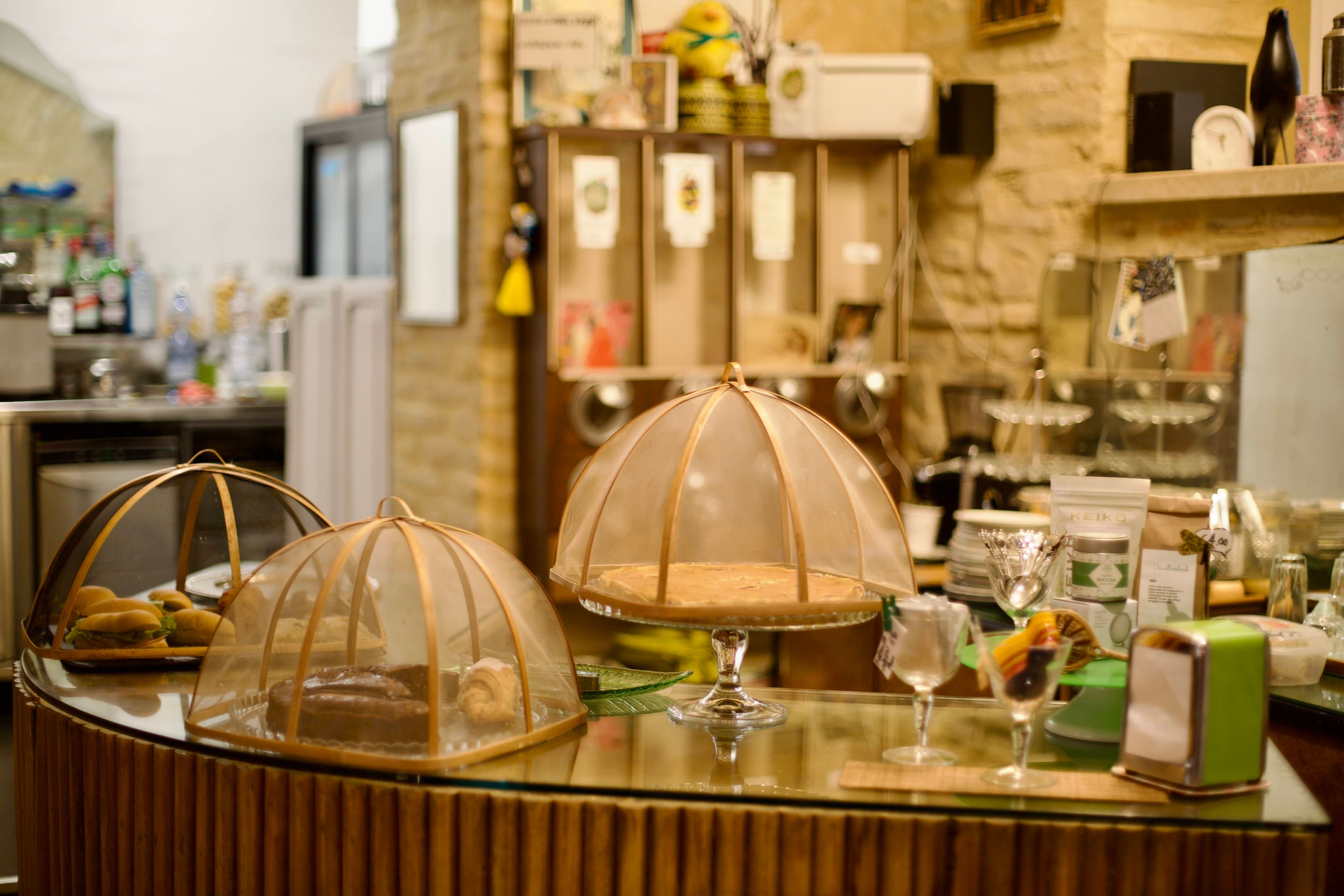 Il banco della sala con torte e dolci sotto le campane